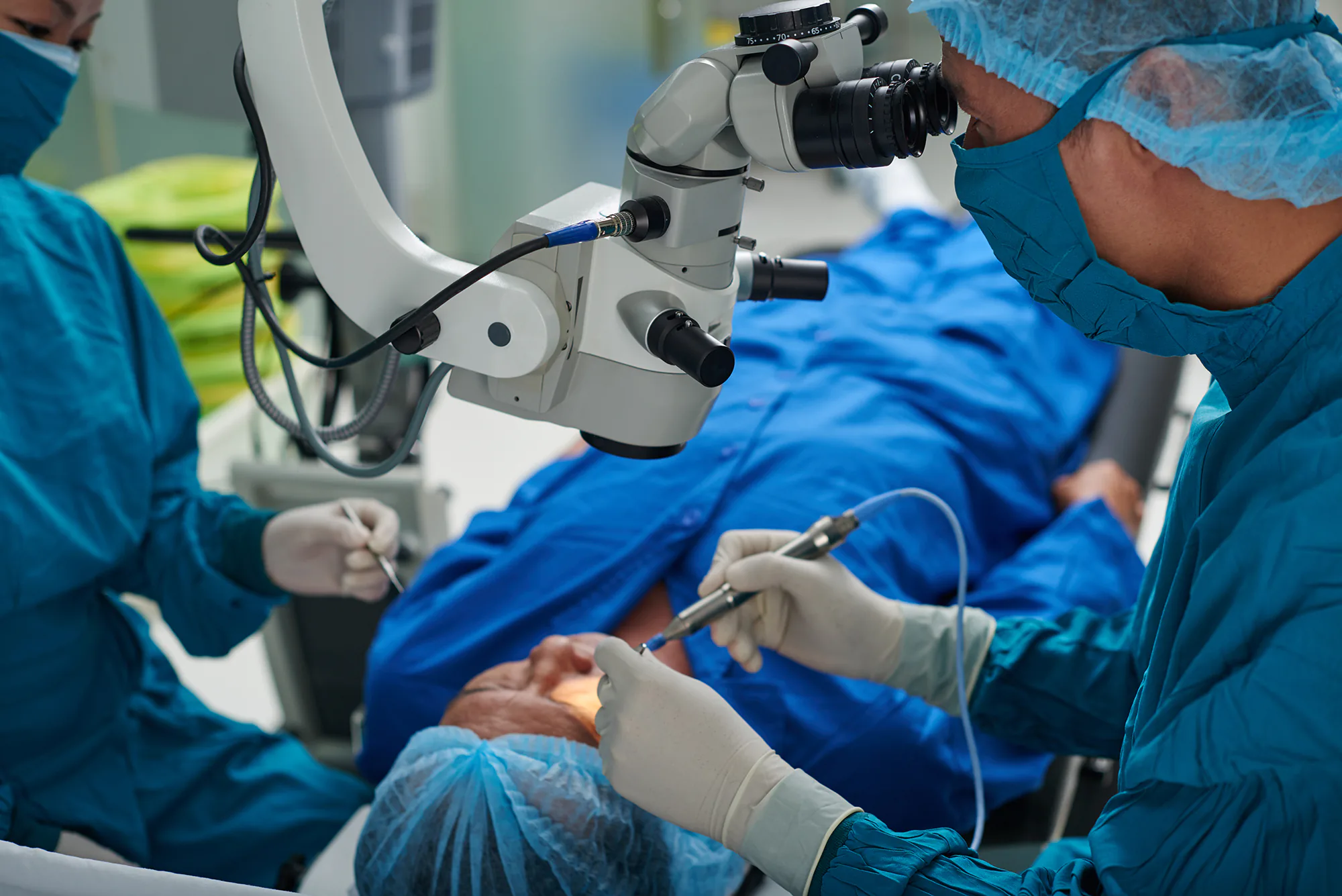 doctors in surgical gowns operating on a patient's eye
